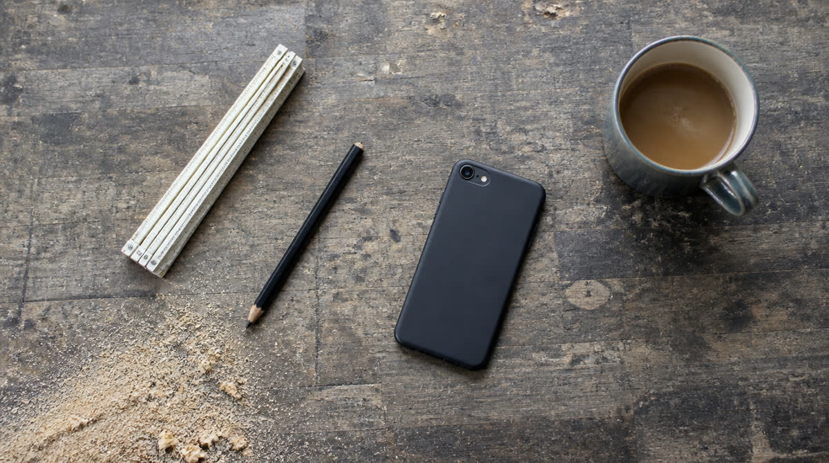Werkbank mit Zollstock, Bleistift, Handy und Kaffeetasse